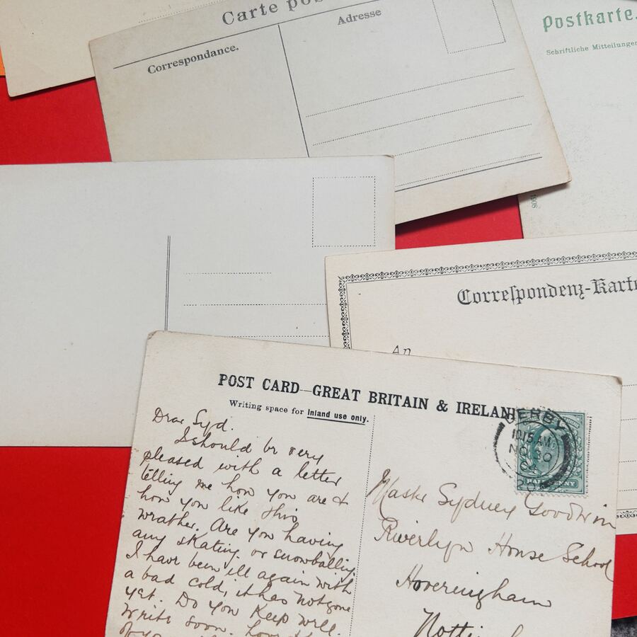 A stack of vintage postcards with Edwardian handwriting